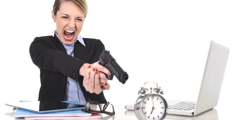 furious angry businesswoman working pointing gun to alarm clock in out of time concept